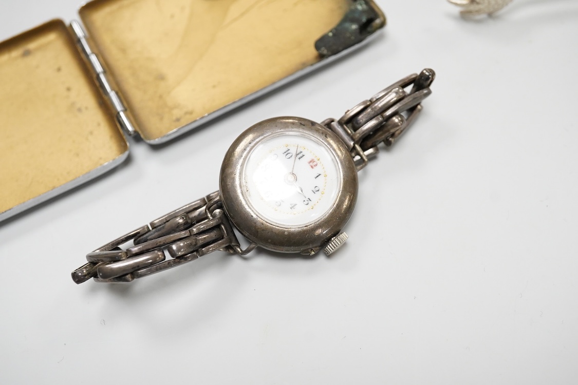 A collection of small silver to include a cigarette case, two napkin rings, three pairs of sugar tongs, a thimble, a lady's wrist watch and a mounted glass toilet jar. together with a 925 fob watch, a 935 mounted lighter